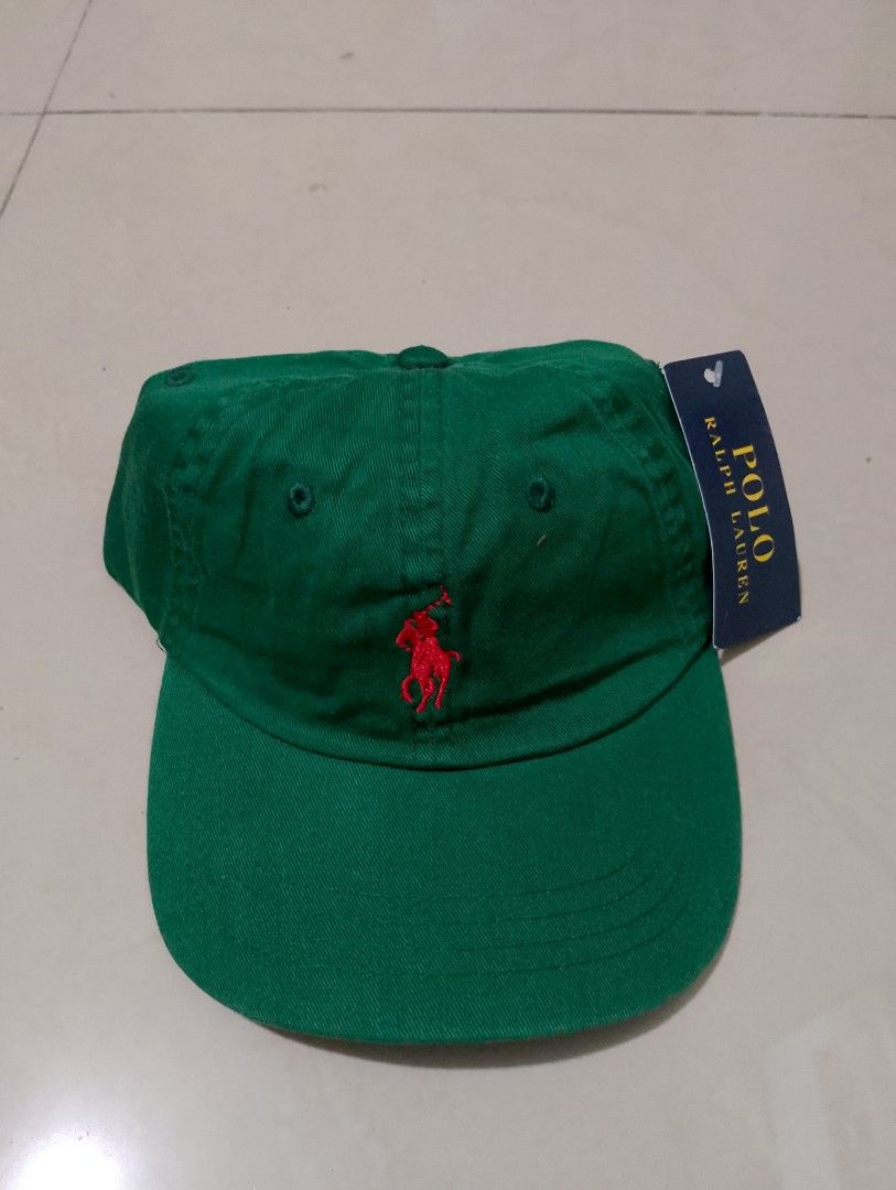 Polo Ralph Lauren Green Baseball Cap (Category: Caps & Hats) located in Manila. Submitted by thriftyboyzzz (Listing ID 1470998503, Image 1). Description: - Brand: Polo Ralph Lauren - Color: Green with red embroidered pony logo - Details: 'POLO' embroidered above the back strap, branded metal strap adjuster - Material: 100% cotton - Size: One size (fits 49cm-56cm) - Condition: Brand new with original tags attached - Origin: Made in Bangladesh.