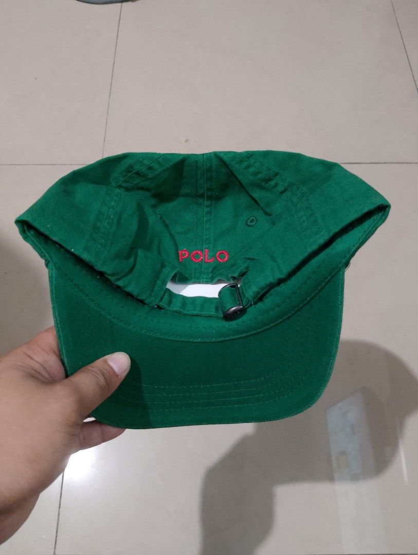 Polo Ralph Lauren Green Baseball Cap (Category: Caps & Hats) located in Manila. Submitted by thriftyboyzzz (Listing ID 1470998503, Image 2). Description: - Brand: Polo Ralph Lauren - Color: Green with red embroidered pony logo - Details: 'POLO' embroidered above the back strap, branded metal strap adjuster - Material: 100% cotton - Size: One size (fits 49cm-56cm) - Condition: Brand new with original tags attached - Origin: Made in Bangladesh.