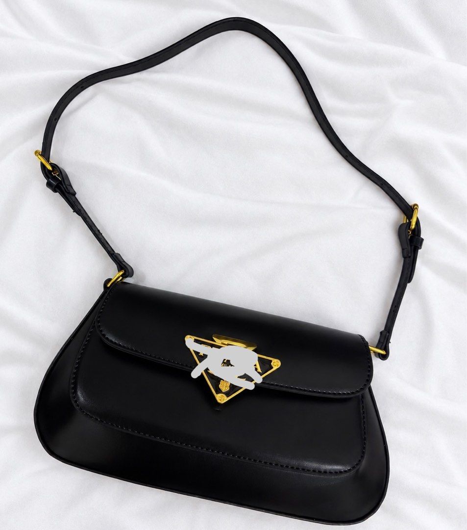 Prada Black Leather Shoulder Bag (Category: Luxury Bags & Wallets) located in Mabalacat. Submitted by davidbianc04942 (Listing ID 1471091960, Image 1). Description: - Brand: Prada - Material: Smooth black leather with gold-tone hardware - Design: Structured silhouette with flap closure and curved bottom edges - Details: Iconic triangular metal logo plaque on the front - Strap: Adjustable thin strap with gold buckles - Interior: Clean and spacious