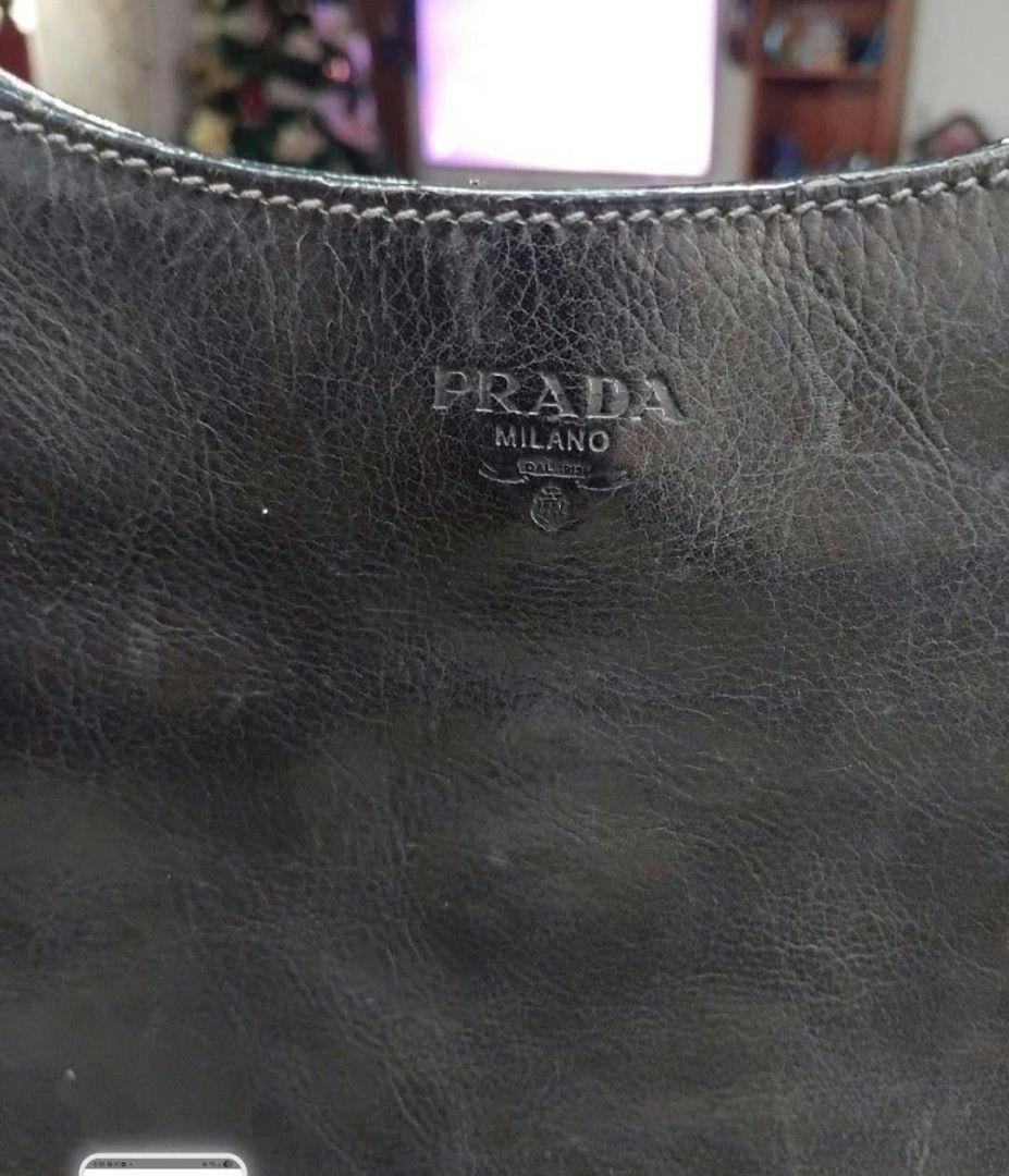 Prada Black Leather Studded Shoulder Bag (Category: Luxury Bags & Wallets) located in Lapu Lapu. Submitted by margaux099 (Listing ID 1471061986, Image 2). Description: - 100% Authentic Prada shoulder bag in classic black leather - Chic silver stud detailing along the edges and strap - Embossed Prada logo on the front - Secure zip top closure - Interior lined with signature Prada fabric - Includes an interior zippered pocket with metal tag and aut