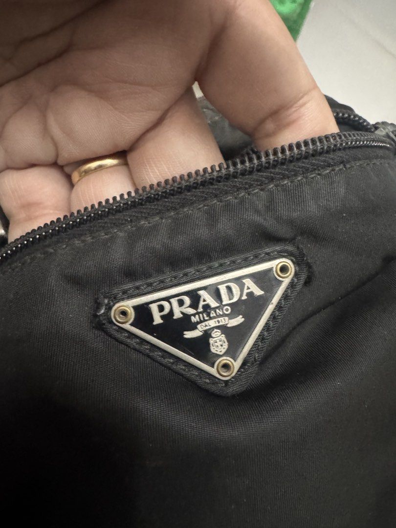 Prada Black Nylon Crossbody Bag (Category: Luxury Bags & Wallets) located in Koronadal. Submitted by milagraciaukayukay123_. (Listing ID 1471097473, Image 2). Description: - Authentic Prada crossbody bag in classic black nylon - Adjustable shoulder strap for comfortable daily wear - Secure front zip pocket with sleek silver-tone hardware - Features the iconic Prada enamel triangle logo on the front - Spacious interior with 'Made in Italy' plaque 