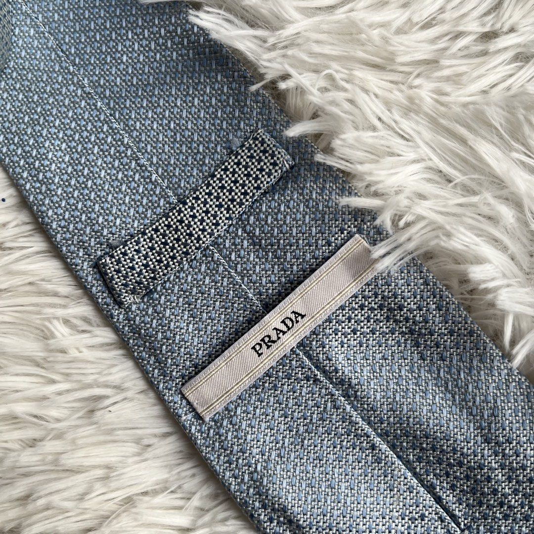 Prada Blue Textured Silk Tie (Category: Ties) located in Cuyapo. Submitted by Ashtyn.Pre.Loved (Listing ID 1471019347, Image 2). Description: - Brand: Prada - Material: Premium silk - Color/Pattern: Textured blue weave - Width: Standard (approx. 3 inches across the blade) - Details: Branded label on back keeper loop - Condition: Clean and ready to wear - Perfect for: Work, interviews, weddings, or formal events.