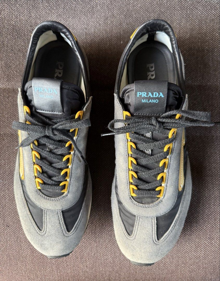 Prada Grey and Yellow Sneakers Size 8 (Category: Sneakers & Footwear) located in Iloilo. Submitted by darvoza (Listing ID 1470961611, Image 1). Description: Grey and black Prada sneakers with bright yellow accents. Suede and fabric panels across the upper. Yellow eyelets holding black laces. Leather trim along the collar and side branding. Textured rubber soles with heavy grip treads underneath. Size 8 stamped on the inner tongue tag alongside st