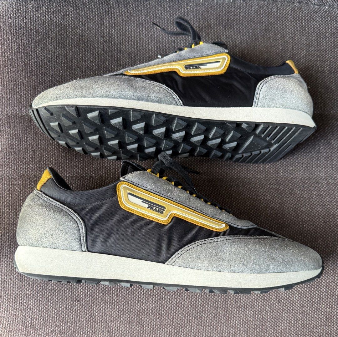 Prada Grey and Yellow Sneakers Size 8 (Category: Sneakers & Footwear) located in Iloilo. Submitted by darvoza (Listing ID 1470961611, Image 2). Description: Grey and black Prada sneakers with bright yellow accents. Suede and fabric panels across the upper. Yellow eyelets holding black laces. Leather trim along the collar and side branding. Textured rubber soles with heavy grip treads underneath. Size 8 stamped on the inner tongue tag alongside st