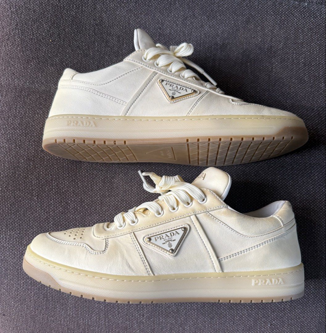 Prada Milano Leather Sneakers Cream White (Category: Sneakers & Footwear) located in Iloilo. Submitted by darvoza (Listing ID 1470965440, Image 2). Description: Prada leather sneakers in cream white colourway. Iconic enameled metal triangle logo on the sides. Perforated toe box and thick rubber soles. Classic low-top silhouette with wide tonal laces. Debossed Prada lettering on the tongue, heel, and side midsole. Made in Italy, model code 2EE364.