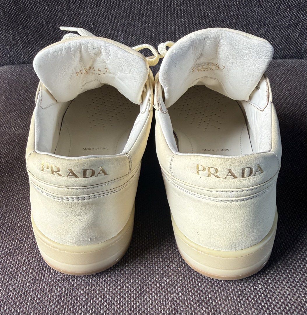 Prada Milano Leather Sneakers Cream White (Category: Sneakers & Footwear) located in Iloilo. Submitted by darvoza (Listing ID 1470965440, Image 3). Description: Prada leather sneakers in cream white colourway. Iconic enameled metal triangle logo on the sides. Perforated toe box and thick rubber soles. Classic low-top silhouette with wide tonal laces. Debossed Prada lettering on the tongue, heel, and side midsole. Made in Italy, model code 2EE364.