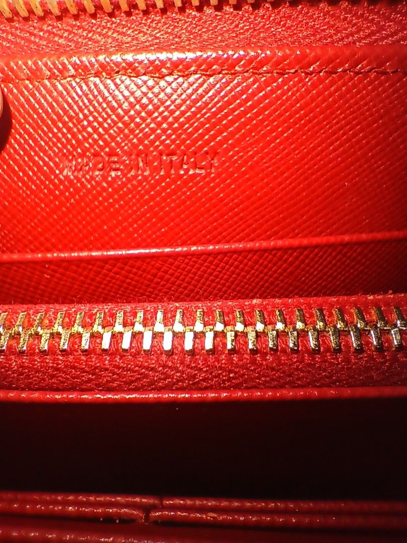 Prada saffiano leather zip around long wallet (Category: Wallets & Card holders) located in Quezon City. Submitted by threetwotwo2ndaccount (Listing ID 1471110664, Image 3). Description: Prada saffiano leather zip around long wallet made in italy color: red lampo zipper with number code no inclusion issue: ung coin purse medyo madumi bawal sa maselan bawal sa barat.