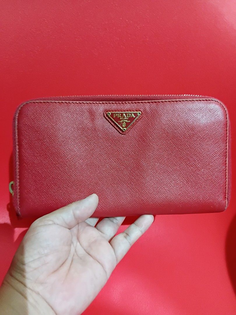 Prada saffiano leather zip around long wallet (Category: Wallets & Card holders) located in Quezon City. Submitted by threetwotwo2ndaccount (Listing ID 1471110664, Image 1). Description: Prada saffiano leather zip around long wallet made in italy color: red lampo zipper with number code no inclusion issue: ung coin purse medyo madumi bawal sa maselan bawal sa barat.