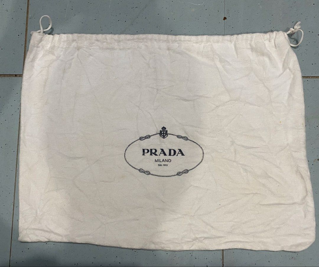 Prada White Dust Bag (Category: Luxury Bags & Wallets) located in Davao. Submitted by dandeshop (Listing ID 1471089154, Image 1). Description: - 100% Authentic Prada dust bag in clean white fabric - Features the iconic Prada Milano logo on the front - Secure double drawstring closure with white cords - Interior tag confirms 100% cotton, Made in Italy - Perfect for storing and protecting your designer bags and accessories.