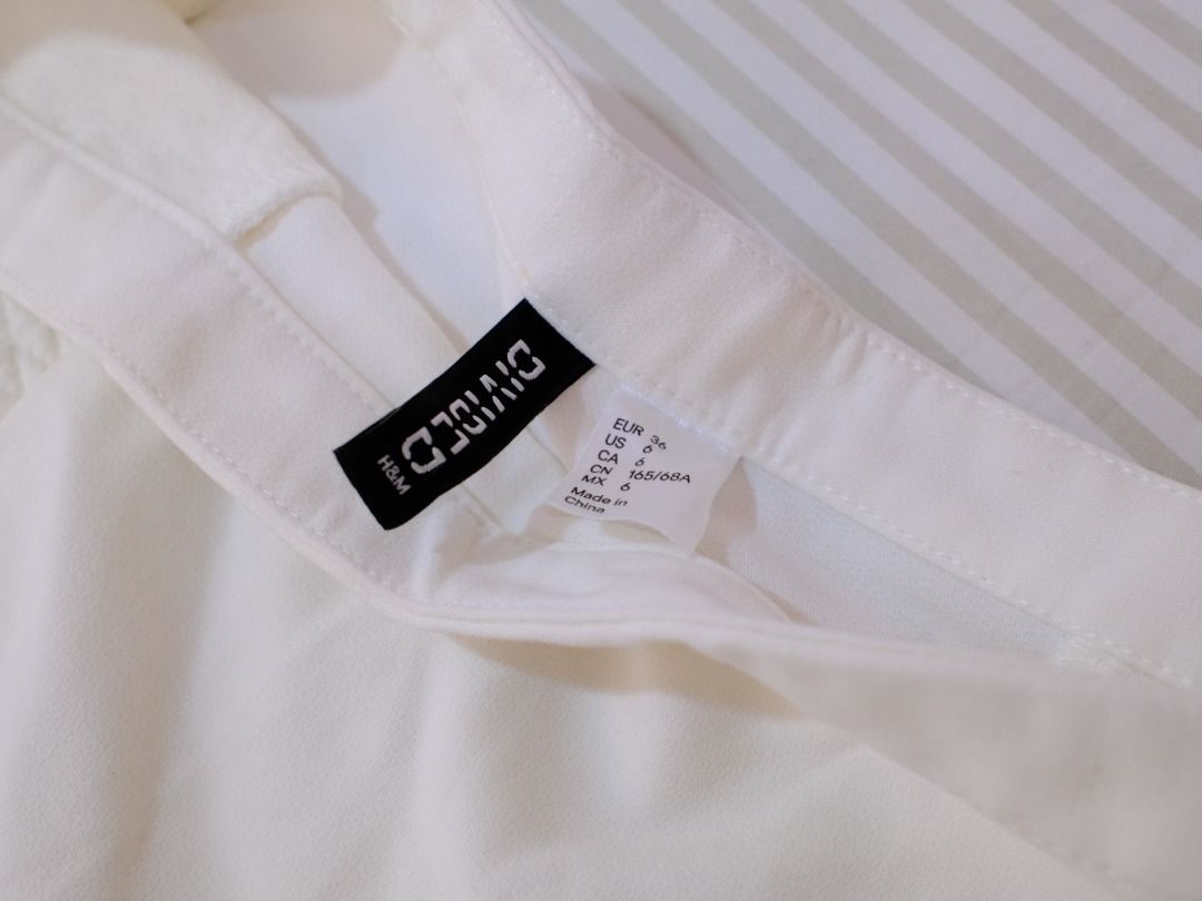 Pre-Loved Clothes | H&M Divided White Mini Skirt with Extra Button (Category: Skirts) located in Obando. Submitted by chokbotsss (Listing ID 1471014963, Image 3). Description: Pre-Loved Clothes - Price: 100 - Brand: H&M - Color: White - Size: M - Issue: Has greenish stain on the back side Payment: Gcash/Bank Transfer Delivery: Lalamove/LBC Location: Maysilo, Malabon City.