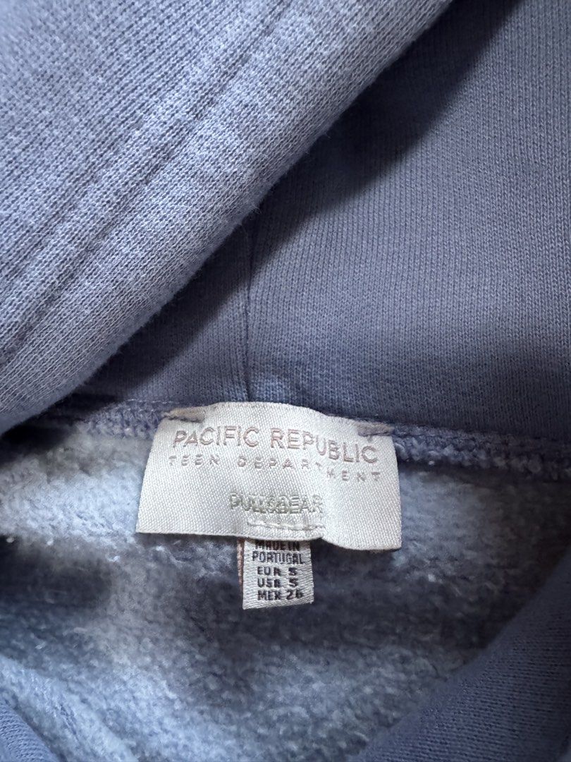 Pull&Bear Blue Graphic Hoodie Size S (Category: Coats, Jackets and Outerwear) located in Manila. Submitted by haobinz_01 (Listing ID 1471020137, Image 3). Description: - Brand: Pull & Bear (Pacific Republic Collection) - Color: Muted blue - Size: Small (EUR/USA/MEX) - Material/Origin: Made in Portugal - Features: Adjustable drawstring hood, front kangaroo pocket.