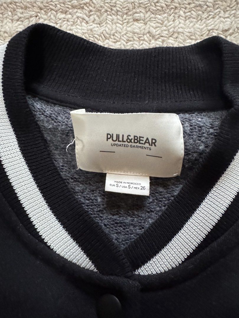 Pull&Bear California Coastline Varsity Jacket Black White (Category: Coats, Jackets and Outerwear) located in Manila. Submitted by haobinz_01 (Listing ID 1471020300, Image 3). Description: - Brand: Pull&Bear - Style: Varsity jacket in black with contrasting white sleeves - Size: S (Made in Morocco) - Details: Snap button closure, striped ribbed collar, cuffs, and hem - Design: 'California Coastline Laguna Beach' embroidered lettering on the left 