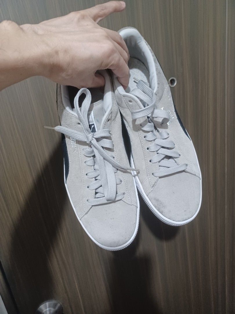 Puma Suede Classic Grey Black Sneakers (Category: Sneakers) located in Mandaluyong City. Submitted by usamenfashionhaul (Listing ID 1471113724, Image 2). Description: - Brand/Model: Puma Suede Sneakers - Color: Grey and black with white rubber soles and matching grey laces - Design: Classic low-top with iconic Puma branding on the side and heel tab - Style: Comfortable everyday streetwear - Condition: Minor signs of wear on the suede upper.