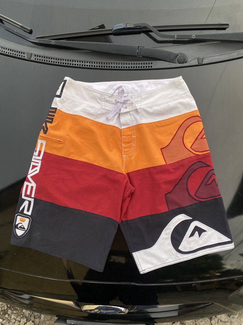 Quiksilver Colorblock Board Shorts Size 30 (Category: Swim Trunks & Board Shorts) located in Manila. Submitted by thriftmar (Listing ID 1471006537, Image 1). Description: - Brand: Quiksilver - Style Number: DOMBS332 - Size: 30 - Design: Multi-color panels (white, orange, red, black) with large vertical branding and mountain wave graphics - Features: Secure zip pocket on the right leg and lace-up drawstring closure at the waist - Condition: Excell