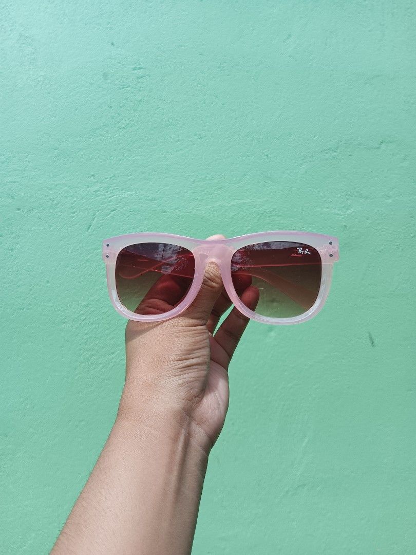 Ray-Ban Clear Pink Gradient Sunglasses (Category: Sunglasses & Eyewear) located in Silang. Submitted by amara_apparel (Listing ID 1471112837, Image 1). Description: - Brand: Ray-Ban - Frame: Classic square shape - Lenses: Gradient tint (dark to light) with signature Ray-Ban logo on the right lens - Details: Metal hinge rivets at front corners - Fit: Lightweight and comfortable for all-day wear - Style: Versatile daily sunnies that match any casua
