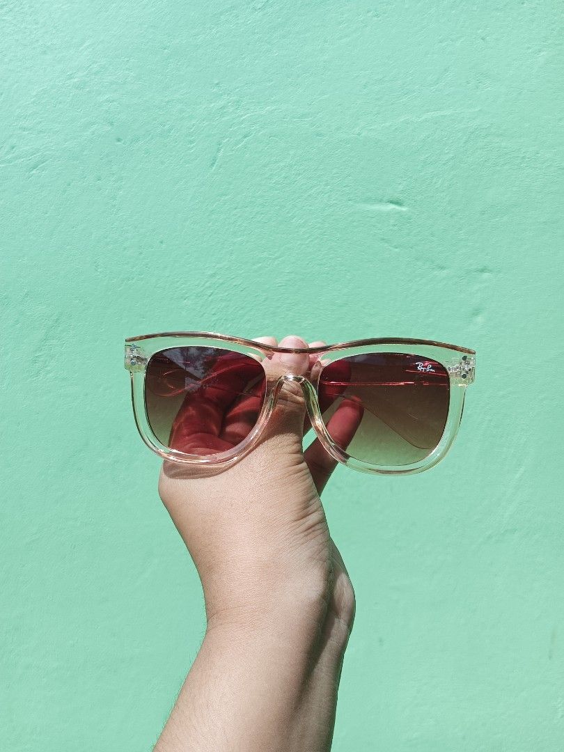 Ray-Ban Clear Pink Gradient Sunglasses (Category: Sunglasses & Eyewear) located in Silang. Submitted by amara_apparel (Listing ID 1471112837, Image 3). Description: - Brand: Ray-Ban - Frame: Classic square shape - Lenses: Gradient tint (dark to light) with signature Ray-Ban logo on the right lens - Details: Metal hinge rivets at front corners - Fit: Lightweight and comfortable for all-day wear - Style: Versatile daily sunnies that match any casua
