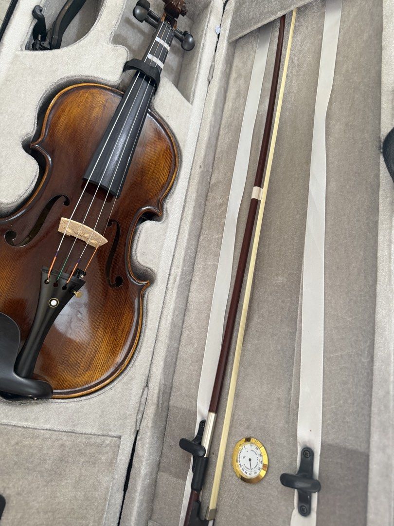 Red Clef Violin (Category: Musical Instruments) located in Paranaque City. Submitted by estheeeer (Listing ID 1471031870, Image 2). Description: - Warm brown acoustic violin, ready for practice or lessons - Features a built-in hygrometer to monitor humidity and protect your instrument - Fingerboard includes taped alignment markers, ideal for beginners - Fitted with a standard bridge and tailpiece with fine tuners - Complete package includes a pad