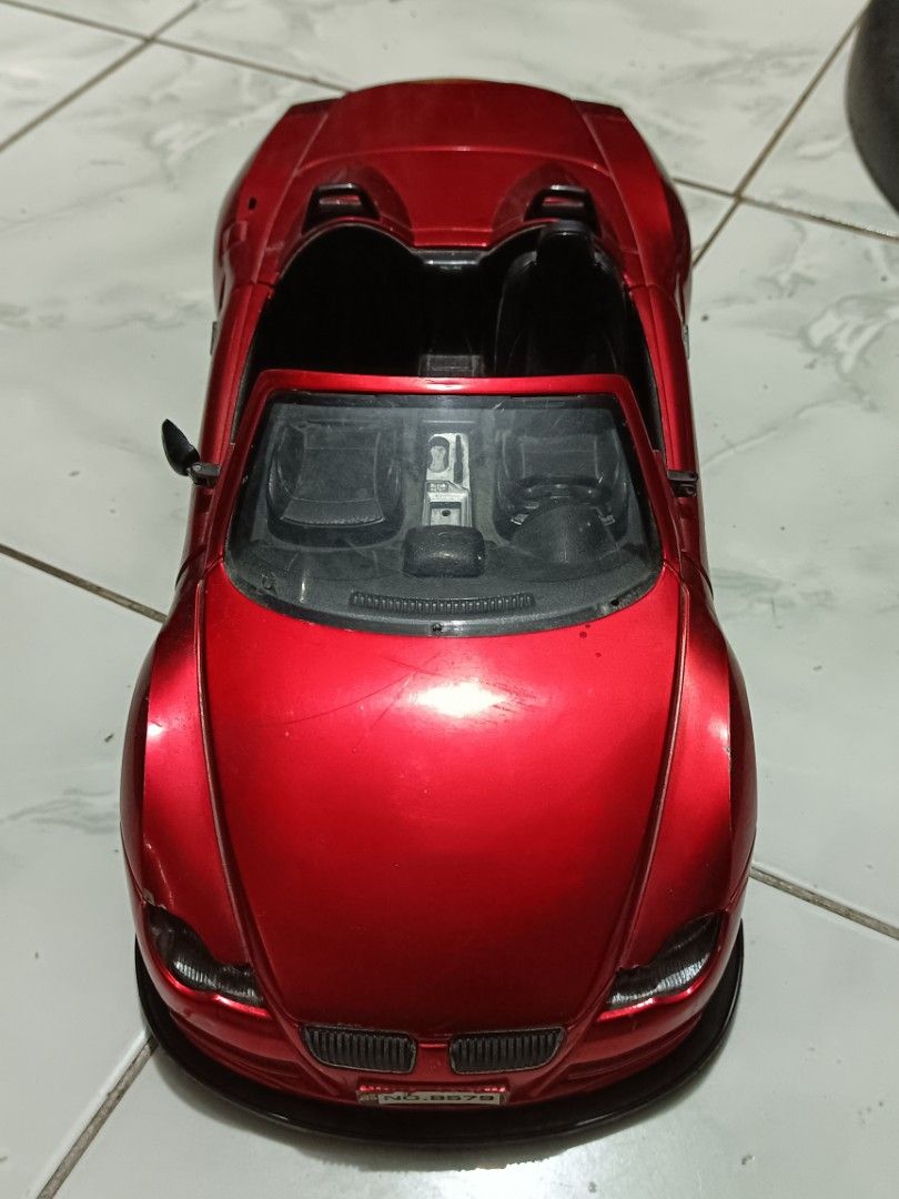 Red convertible toy car model (Category: Vehicle & Diecast Models) located in Manila. Submitted by caaths_collection (Listing ID 1471042522, Image 1). Description: - AS IS - Bright red convertible toy car with smooth-rolling wheels - Detailed interior featuring black seats, steering wheel, and gear shift console - Distinctive dual headrest humps and rear license plate (NO.8579) - Minor scratches on the hood and body from previous play - Perfect a