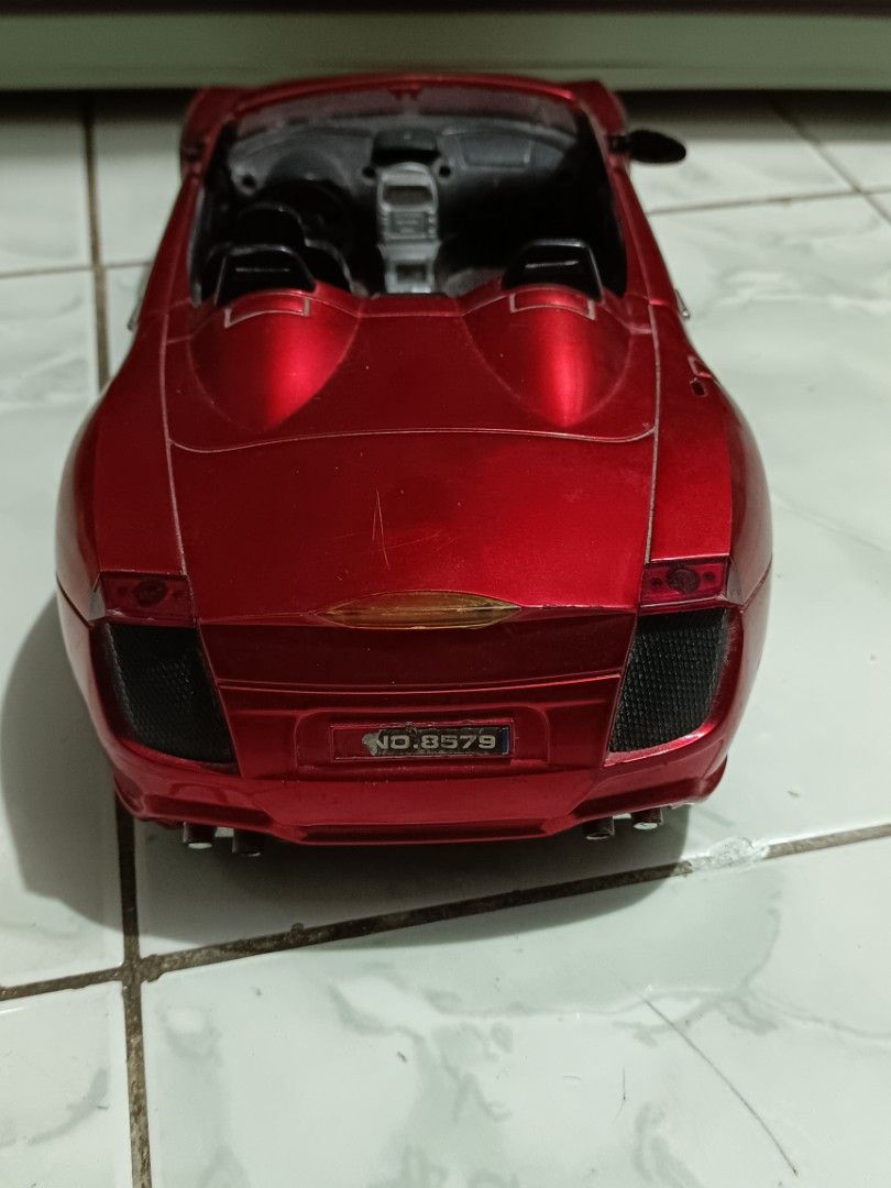 Red convertible toy car model (Category: Vehicle & Diecast Models) located in Manila. Submitted by caaths_collection (Listing ID 1471042522, Image 3). Description: - AS IS - Bright red convertible toy car with smooth-rolling wheels - Detailed interior featuring black seats, steering wheel, and gear shift console - Distinctive dual headrest humps and rear license plate (NO.8579) - Minor scratches on the hood and body from previous play - Perfect a