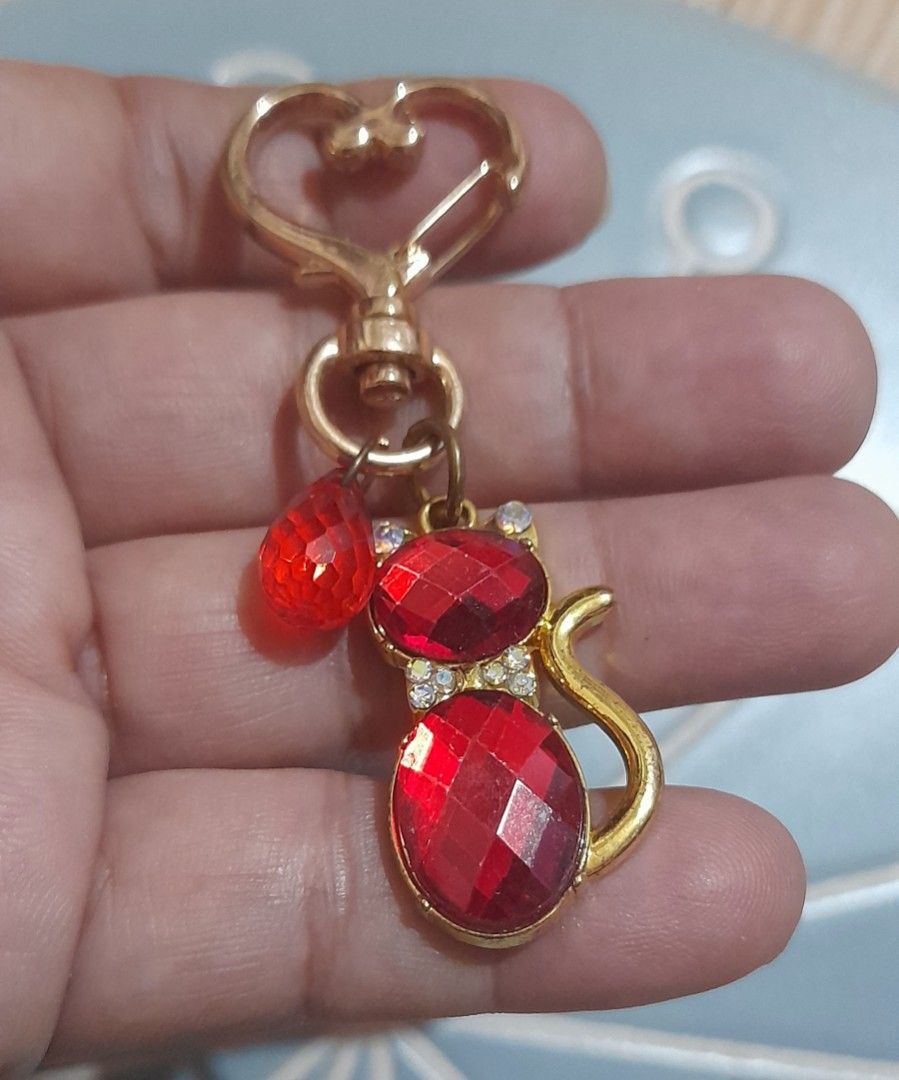 Red Crystal Cat Keychain Gold Hardware Heart Clasp (Category: Charms) located in Bocaue. Submitted by marajapansurplus (Listing ID 1470980516, Image 3). Description: - Adorable gold-tone cat keychain filled with sparkling red faceted crystals - Accentuated with small clear rhinestones around the collar - Features a cute extra dangling red teardrop bead - Equipped with a smooth, reliable heart-shaped clasp - Plain textured gold metal finish on the