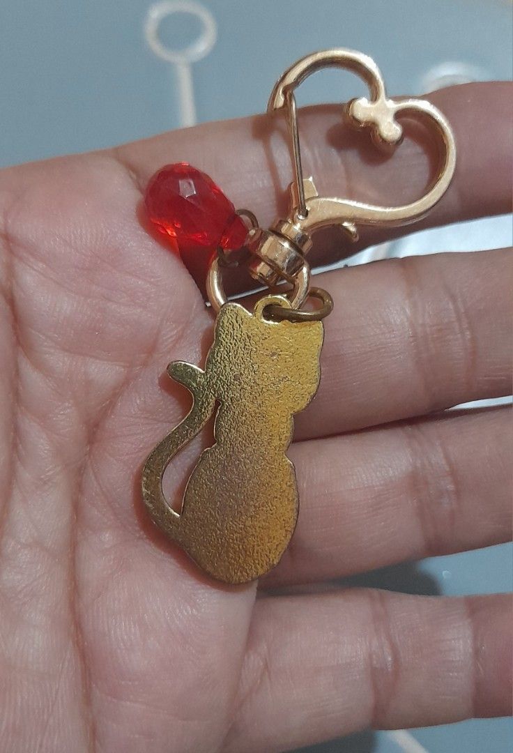 Red Crystal Cat Keychain Gold Hardware Heart Clasp (Category: Charms) located in Bocaue. Submitted by marajapansurplus (Listing ID 1470980516, Image 2). Description: - Adorable gold-tone cat keychain filled with sparkling red faceted crystals - Accentuated with small clear rhinestones around the collar - Features a cute extra dangling red teardrop bead - Equipped with a smooth, reliable heart-shaped clasp - Plain textured gold metal finish on the