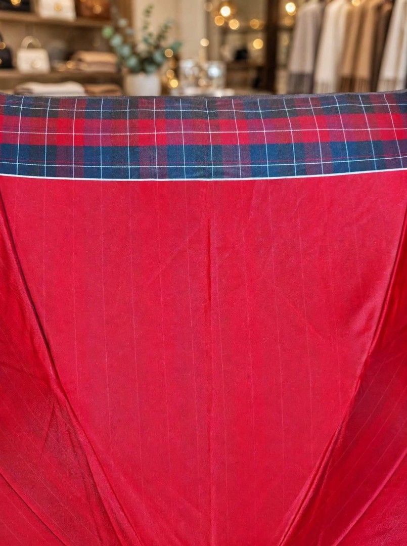 Red Foldable Umbrella with Tartan Plaid Trim (Category: Umbrellas) located in Caloocan City. Submitted by chonadura91470 (Listing ID 1471104909, Image 2). Description: - Color: Deep red with subtle vertical striping and classic tartan plaid trim - Design: Foldable with a dark frame and black handle featuring a convenient wrist strap - Portability: Collapses down neatly into a compact matching sleeve with a button closure - Condition: Solid constr