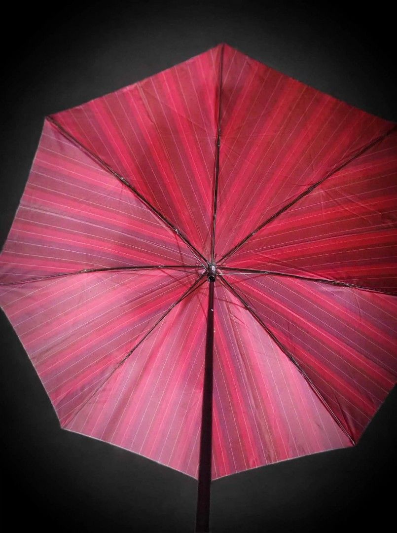 Red Foldable Umbrella with Tartan Plaid Trim (Category: Umbrellas) located in Caloocan City. Submitted by chonadura91470 (Listing ID 1471104909, Image 3). Description: - Color: Deep red with subtle vertical striping and classic tartan plaid trim - Design: Foldable with a dark frame and black handle featuring a convenient wrist strap - Portability: Collapses down neatly into a compact matching sleeve with a button closure - Condition: Solid constr