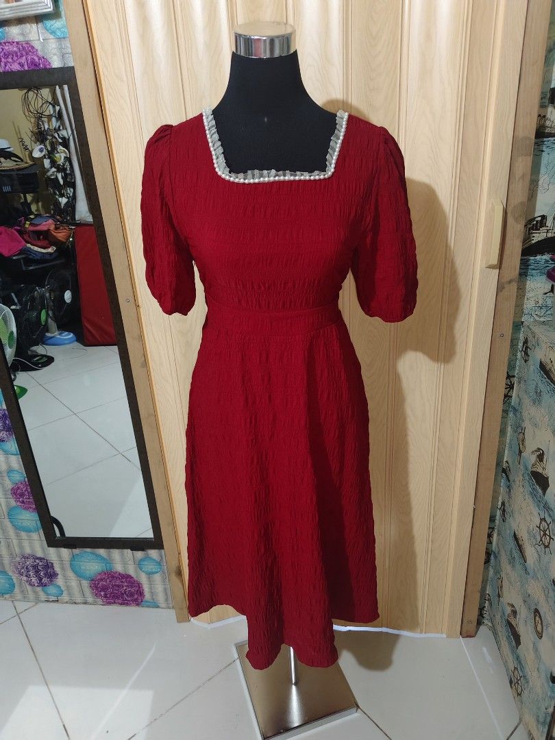 Red Maxi Dress With Pearl Collar (Category: Dresses) located in Manila. Submitted by duffy-080 (Listing ID 1471056546, Image 2). Description: Red midi dress from Xin Fu Shi. Square neckline trimmed with tiny white pearls and ruffled fabric. Short puffed sleeves and smocked textured fabric throughout. Back features a tie-up ribbon closure at the neck. Midi length with a fitted bodice and flared skirt..