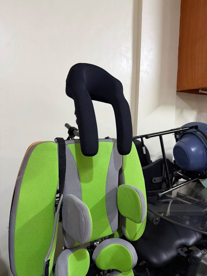 Rehatec pediatric standing frame green and grey (Category: Medical Supplies & Tools) located in Manila. Submitted by calmdolphin.87b0e4 (Listing ID 1470957310, Image 3). Description: - Pediatric therapeutic standing frame with green and grey padding - Includes headrest, secure torso straps, and adjustable knee blocks - Wooden footplates equipped with foot straps for stability - Mounted on a mobile wheeled base for easy repositioning - Features bu