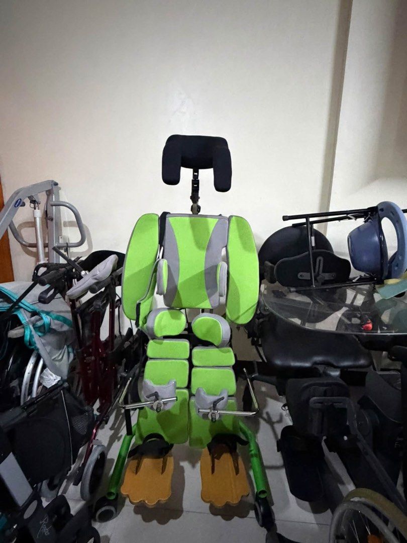 Rehatec pediatric standing frame green and grey (Category: Medical Supplies & Tools) located in Manila. Submitted by calmdolphin.87b0e4 (Listing ID 1470957310, Image 1). Description: - Pediatric therapeutic standing frame with green and grey padding - Includes headrest, secure torso straps, and adjustable knee blocks - Wooden footplates equipped with foot straps for stability - Mounted on a mobile wheeled base for easy repositioning - Features bu
