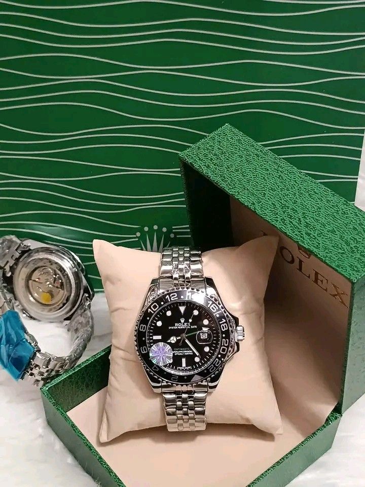 Rolex GMT-Master II Automatic Watch with Box (Category: Luxury Watches) located in Manila. Submitted by silvermoon_b802e0 (Listing ID 1471061958, Image 1). Description: Rolex GMT-Master II watch in green presentation box. Stainless steel bracelet with protective blue plastic wrap still attached. Rotating bezel with red and blue accents. Textured dial with date window at the three o'clock position. Exhibition glass case back exposing automatic mov