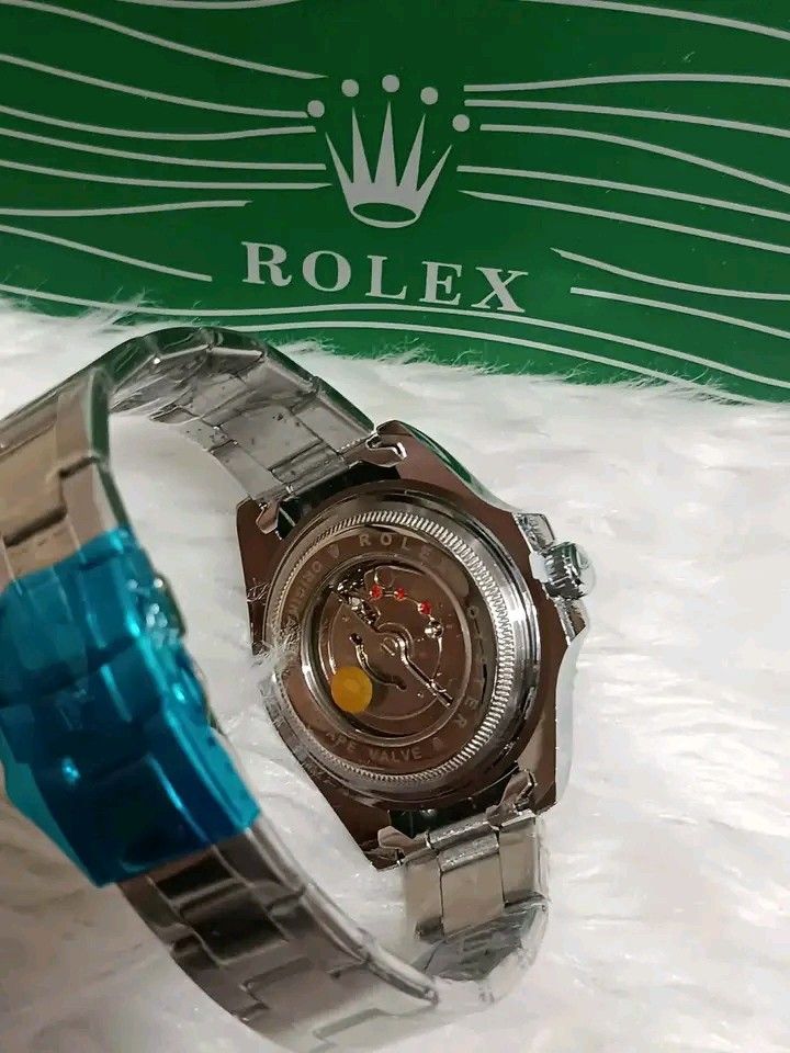 Rolex GMT-Master II Automatic Watch with Box (Category: Luxury Watches) located in Manila. Submitted by silvermoon_b802e0 (Listing ID 1471061958, Image 2). Description: Rolex GMT-Master II watch in green presentation box. Stainless steel bracelet with protective blue plastic wrap still attached. Rotating bezel with red and blue accents. Textured dial with date window at the three o'clock position. Exhibition glass case back exposing automatic mov