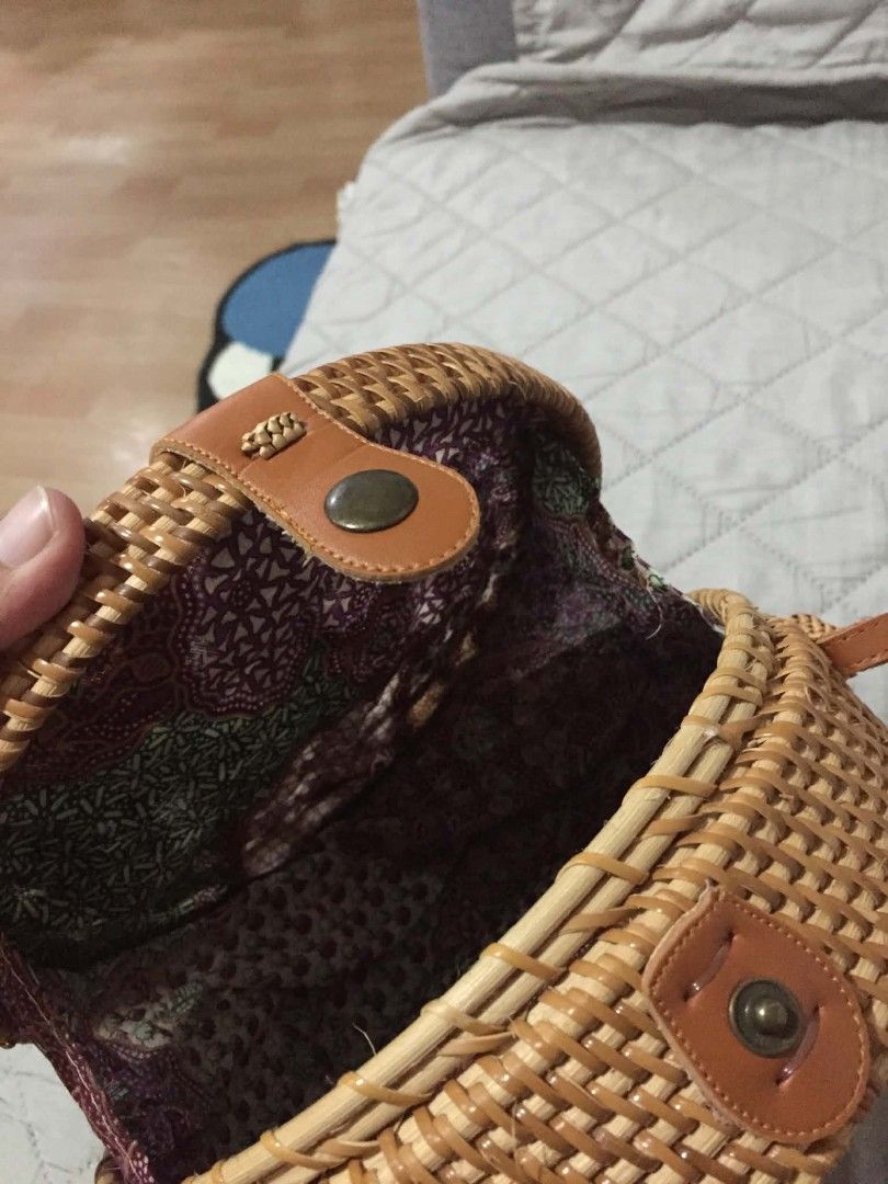 Round Rattan Crossbody Bag with Batik Lining (Category: Cross-body Bags) located in Muntinlupa City. Submitted by prelovedbyanney (Listing ID 1471090554, Image 2). Description: - Style: Round structured rattan straw bag - Closure: Secure snap button with brown leather strap - Interior: Lined with colorful batik fabric - Wear: Long strap suitable for shoulder or crossbody wear - Texture: Natural woven design throughout.