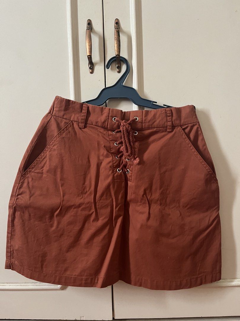 Rust Orange Lace-Up Front Cargo Skirt (Category: Skirts) located in Las Pinas. Submitted by ricaaveve (Listing ID 1470946756, Image 1). Description: - Color: Rust orange - Material: Sturdy cotton-blend fabric for everyday wear - Design: Lace-up drawstring front detail - Pockets: Front slip pockets and two back flap pockets - Fit & Closure: Partial elastic waistband in back with belt loops and a convenient side zipper closure.