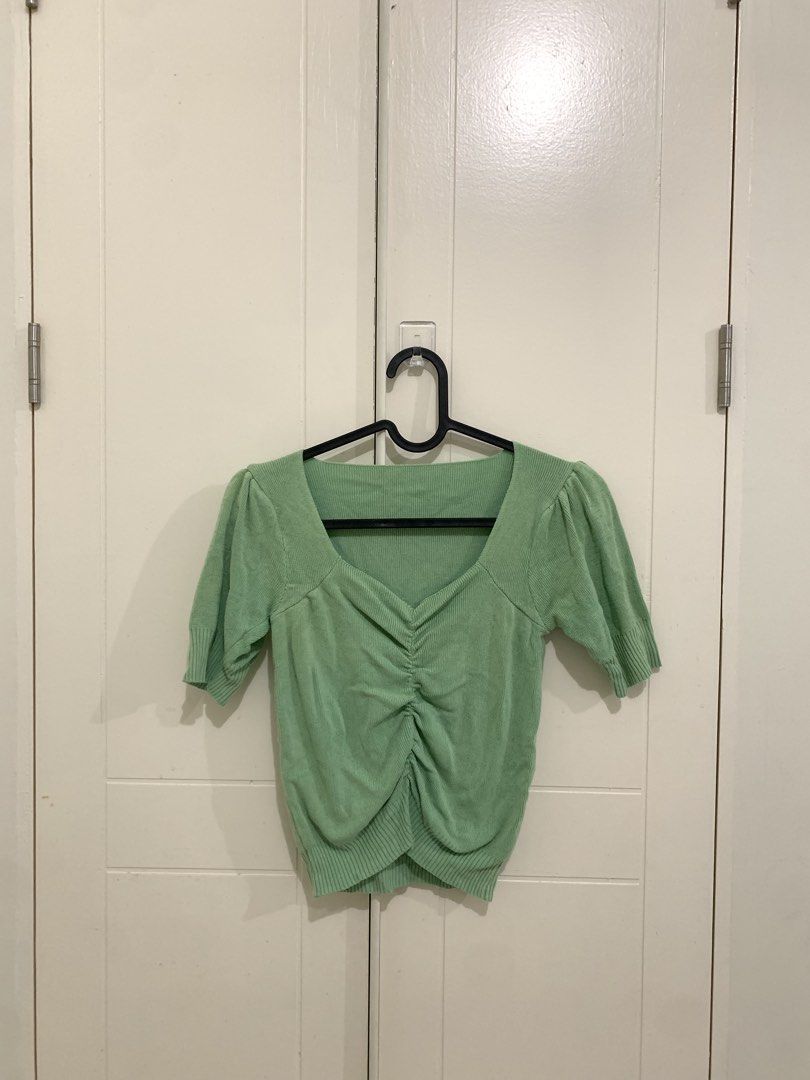 Sage Green Knit Puff Sleeve Ruched Top (Category: Blouses) located in Pasig City. Submitted by lovedbyri (Listing ID 1470953324, Image 1). Description: - Color: Sage green - Style: Fitted knit top with short puff sleeves and square neckline - Details: Ruched front with ribbed texture on collar, cuffs, and hem - Material: Stretchy, super comfortable fabric - Versatility: Great for casual days or paired with high-waisted jeans.