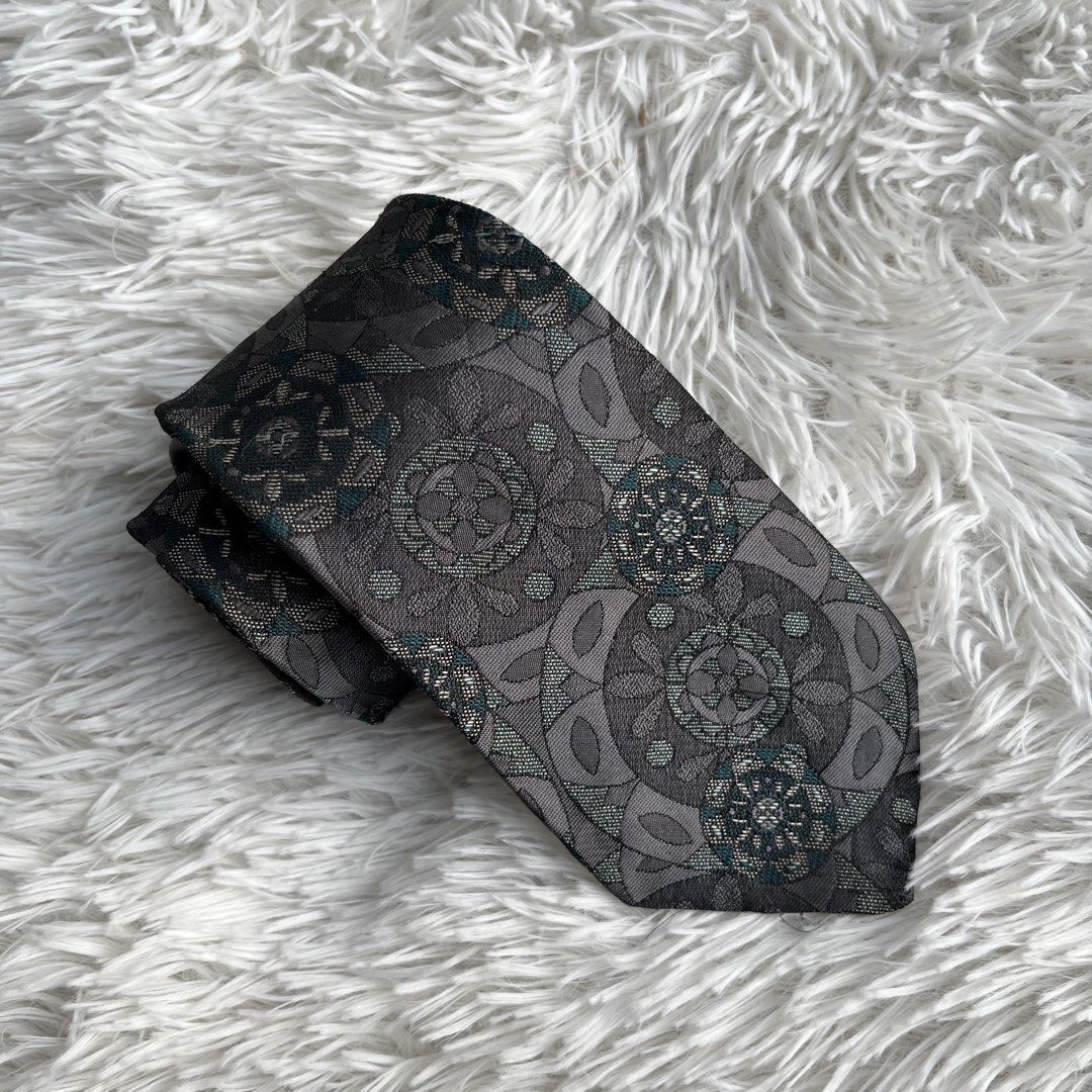 Salvatori Grey Geometric Floral Pattern Necktie (Category: Ties) located in Cuyapo. Submitted by Ashtyn.Pre.Loved (Listing ID 1471020147, Image 1). Description: - Brand: Salvatori - Color: Dark grey with green and silver accents - Design: Detailed geometric floral pattern - Width: Standard 3.75 inches at the widest point - Condition: Excellent, clean with no pulls or stains - Versatility: Ideal for business casual, office, or formal events.