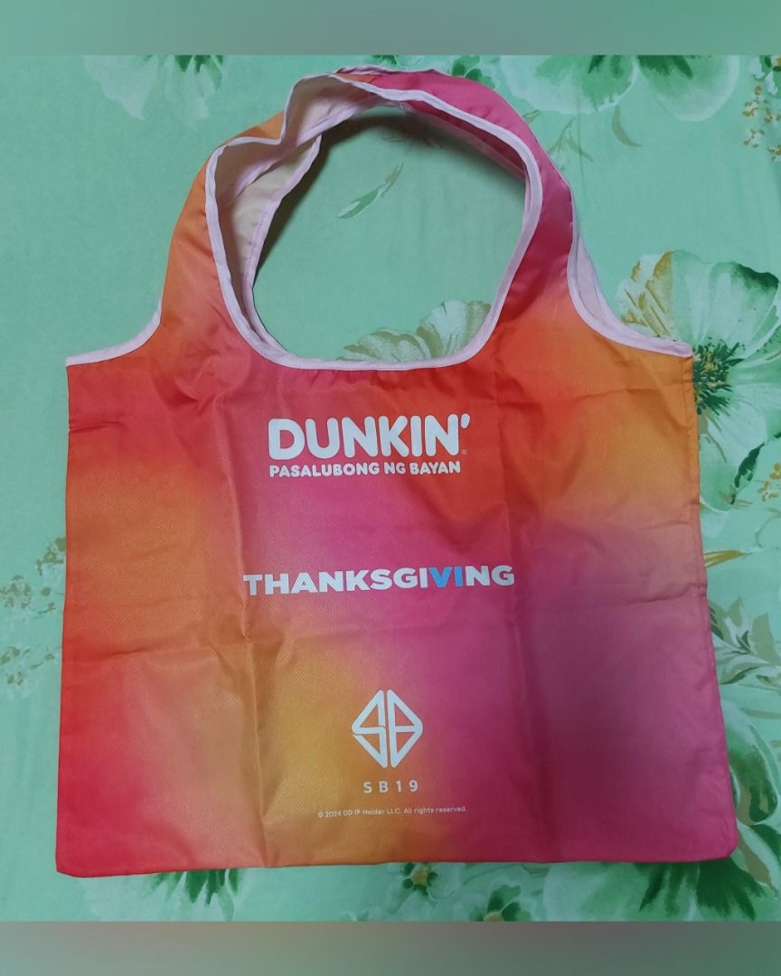 SB19 x Dunkin' Thanksgiving Gradient Reusable Tote Bag (Category: Other Merchandise) located in Pasig City. Submitted by keithra (Listing ID 1470935210, Image 1). Description: - Official Dunkin x SB19 Thanksgiving collaboration merchandise - Eye-catching gradient design in pink, orange, and yellow with clear printed logos - Reusable shopping bag style with comfortable built-in handles - Lightweight fabric that folds up easily for convenient stora