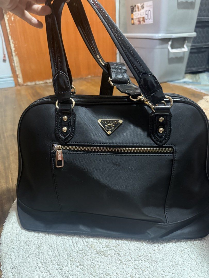 Secosana Black Nylon Shoulder Bag with Gold Hardware (Category: Luxury Bags & Wallets) located in Pasig City. Submitted by patrissia1129 (Listing ID 1470979268, Image 1). Description: - Brand: Secosana - Material: Durable black nylon with chic gold-tone hardware - Exterior: Front zippered pocket with iconic triangular brand plaque - Straps: Dual top handles plus an adjustable patterned shoulder strap for versatile wear - Interior: Branded printed