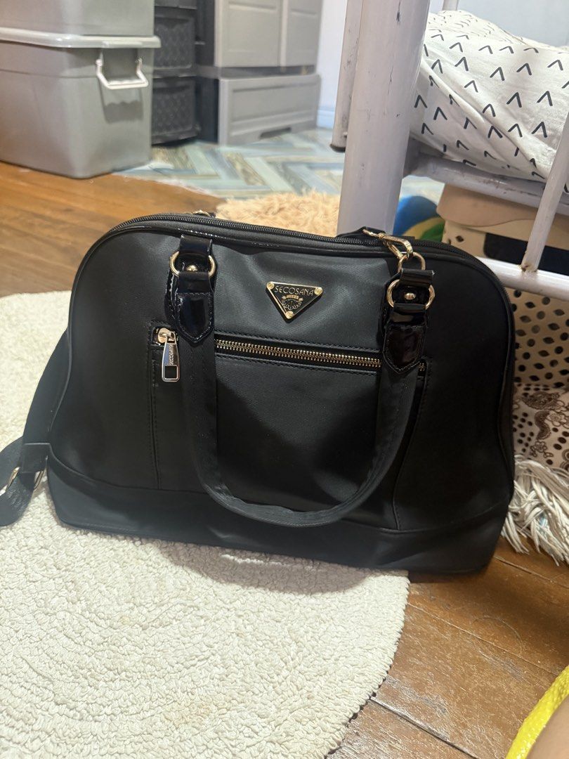 Secosana Black Nylon Shoulder Bag with Gold Hardware (Category: Luxury Bags & Wallets) located in Pasig City. Submitted by patrissia1129 (Listing ID 1470979268, Image 2). Description: - Brand: Secosana - Material: Durable black nylon with chic gold-tone hardware - Exterior: Front zippered pocket with iconic triangular brand plaque - Straps: Dual top handles plus an adjustable patterned shoulder strap for versatile wear - Interior: Branded printed