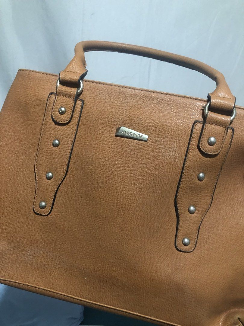Secosana Tan Handbag and Blue Shoulder Bag Bundle (Category: Shoulder Bags) located in General Trias. Submitted by dmcwl (Listing ID 1471050395, Image 3). Description: PRELOVED BAGS FOR SALE! BUNDLED NA PO ITO FOR THE PRICE. - Bundle includes: Secosana tan structured handbag (with metal studs, logo plate, and zippered back pocket) and a blue bag (with tan straps and wooden tassel charm). - Condition: Clean interiors, minimal signs of wear on the 