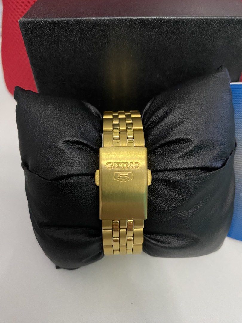 Seiko 5 Automatic Gold Watch with White Dial (Category: Men's Watches) located in Baguio. Submitted by masterroller (Listing ID 1470970577, Image 3). Description: - Brand: Seiko 5 Automatic Watch - Color/Finish: Gold tone casing and matching metal bracelet with folding clasp - Dial: White textured dial with day and date window at 3 o'clock - Movement: 21 jewels automatic movement with exhibition case back - Condition: Minimal wear on casing and b