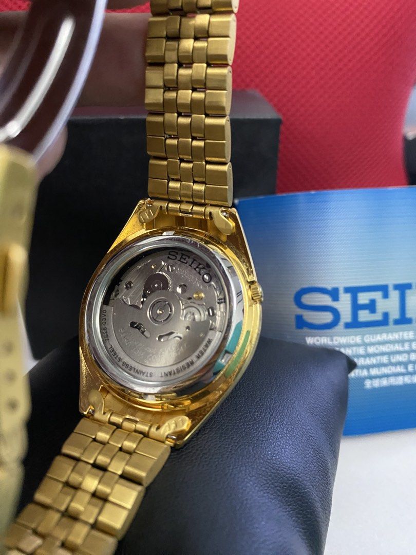 Seiko 5 Automatic Gold Watch with White Dial (Category: Men's Watches) located in Baguio. Submitted by masterroller (Listing ID 1470970577, Image 2). Description: - Brand: Seiko 5 Automatic Watch - Color/Finish: Gold tone casing and matching metal bracelet with folding clasp - Dial: White textured dial with day and date window at 3 o'clock - Movement: 21 jewels automatic movement with exhibition case back - Condition: Minimal wear on casing and b