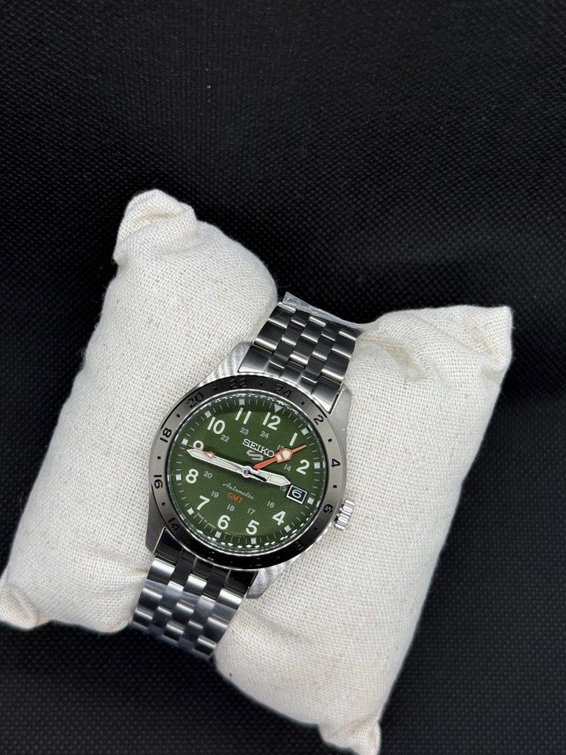 Seiko HDB001j (Category: Men's Watches) located in Quezon City. Submitted by eliboii (Listing ID 1471021991, Image 2). Description: - Model: Seiko 5 Sports Field GMT - Dial: Olive green with bold Arabic numerals and striking orange 24-hour hand for dual time tracking - Movement: Reliable 4R34 automatic movement - Condition: Brand new, stainless steel bracelet still wrapped in protective plastic - Inclusions: Complete with original Seiko presentat