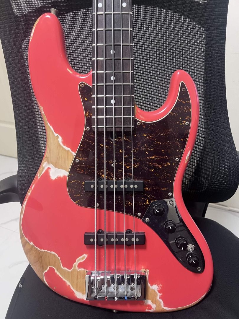 Semitone Model J Custom Relics 5-String Active/Passive Bass Guitar (Category: Musical Instruments) located in Carmona. Submitted by r.redone (Listing ID 1471059604, Image 2). Description: - Brand/Model: Custom relics 5-string electric bass by Semitone - Finish: Coral pink with heavy distressed relic wear and natural wood exposure - Construction: Solid body with a bolt-on maple neck and dark fretboard featuring dot markers - Electronics & Hardware