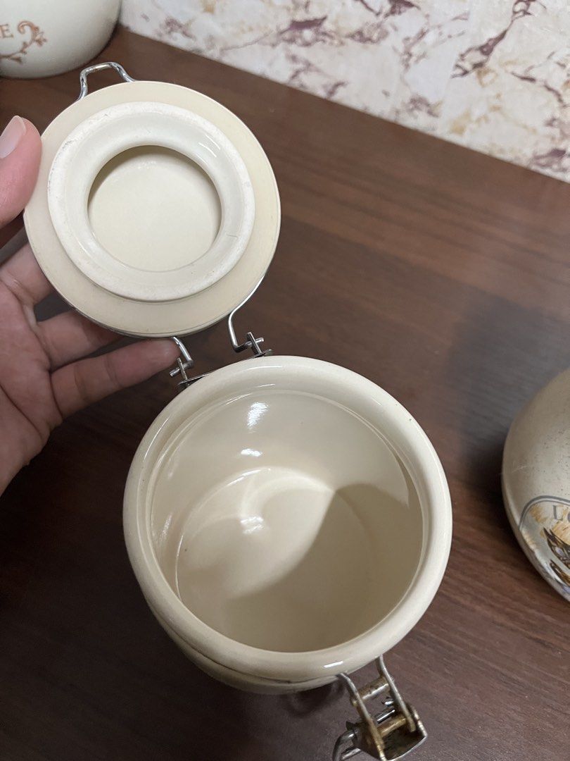 Set of Two Ceramic Canisters with Latching Lids (Category: Food Organization & Storage) located in Manila. Submitted by kayerrr.gem (Listing ID 1471046335, Image 3). Description: - Set of 2 ceramic storage jars with secure metal latch closures and rubber seals - Features off-white speckled glaze design on both jars - One jar has a charming 'Lovely Duck For A Friend' graphic - Second jar includes a blank yellow sticker for custom labeling - Metal 