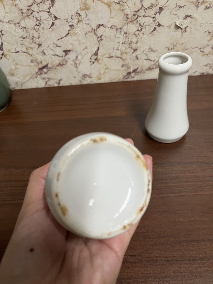 Set of two white ceramic bud vases (Category: Vases & Decorative Bowls) located in Manila. Submitted by kayerrr.gem (Listing ID 1471046929, Image 3). Description: - Set of 2 white ceramic vases in varying heights - Minimalist modern style with flared bases and rounded rims - Smooth, glossy glaze finish - Ideal for single stems or small floral arrangements - Neutral tone complements any home decor - Condition: Bottoms show minor wear and discolora