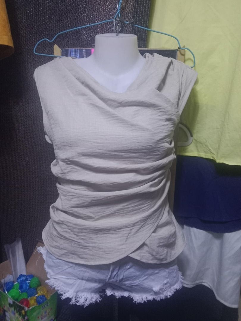 SHEIN Beige Sleeveless Draped Top XS (Category: Sleeveless) located in Quezon City. Submitted by honeyonline.ph (Listing ID 1471041613, Image 1). Description: - Brand: Shein - Size: XS (tag attached) - Color: Neutral beige - Material: 100% textured polyester - Design: Asymmetrical draped neckline with stylish wrapped front and back - Closure: Side zipper - Fit: Slim fit - Care: Hand wash recommended.