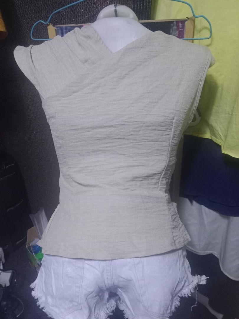 SHEIN Beige Sleeveless Draped Top XS (Category: Sleeveless) located in Quezon City. Submitted by honeyonline.ph (Listing ID 1471041613, Image 2). Description: - Brand: Shein - Size: XS (tag attached) - Color: Neutral beige - Material: 100% textured polyester - Design: Asymmetrical draped neckline with stylish wrapped front and back - Closure: Side zipper - Fit: Slim fit - Care: Hand wash recommended.