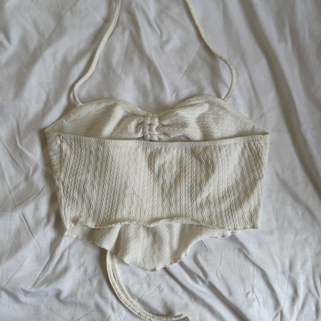 Shein White Textured Halter Top (Category: Sleeveless) located in Cavite. Submitted by kydeclutter (Listing ID 1470993063, Image 2). Description: - Style: Halter top with slim tie-neck straps - Details: Textured crinkled fabric, ruched bust with center drawstring tie - Material: Lightweight and breezy, perfect for summer - Condition: Has minor stains, a little bit off-white from repeated use.