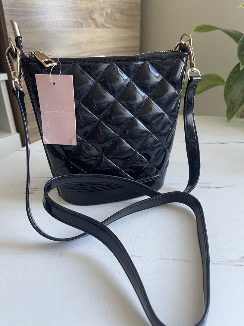 SM Accessories Black Quilted Shoulder Bag (Category: Shoulder Bags) located in Paranaque City. Submitted by honest_stuff (Listing ID 1470991887, Image 2). Description: - Brand: SM Accessories (Pink tag still attached) - Material: Black glossy shiny patent finish - Design: Quilted bucket bag with front gold chain link detail - Closure: Top zipper - Strap: Comes with adjustable and detachable black shoulder strap - Condition: Brand new.